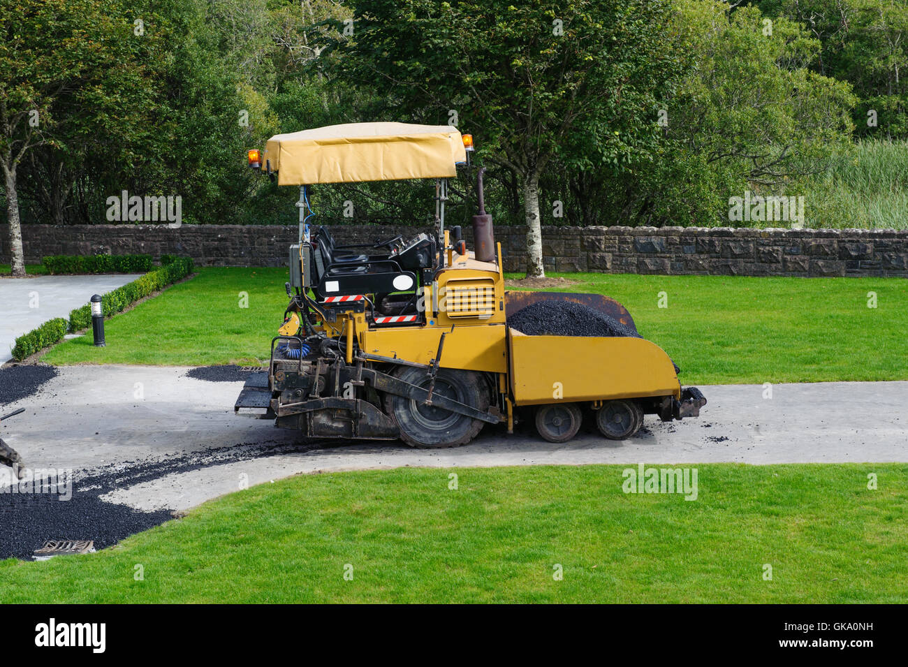 asphalt spreader machine with yellow color working in outside Stock Photo
