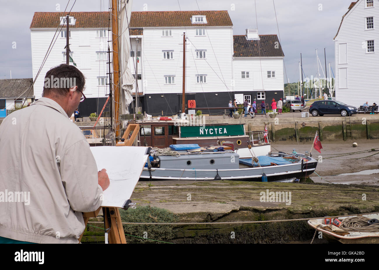 A male artist sketches the Tide Mill in Woodbridge Suffolk England Stock Photo
