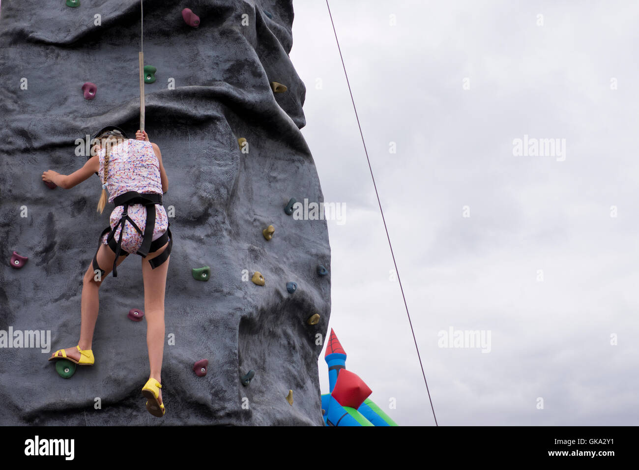 young climb climbing an artificial rock face in Aldeburgh in Suffolk in