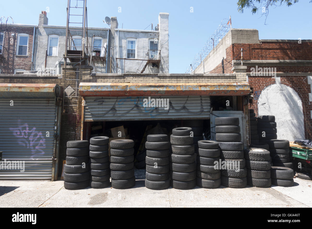 Used and worn out tires for sale piled up in front of a garage in Flatbush, Brooklyn, NY. Stock Photo