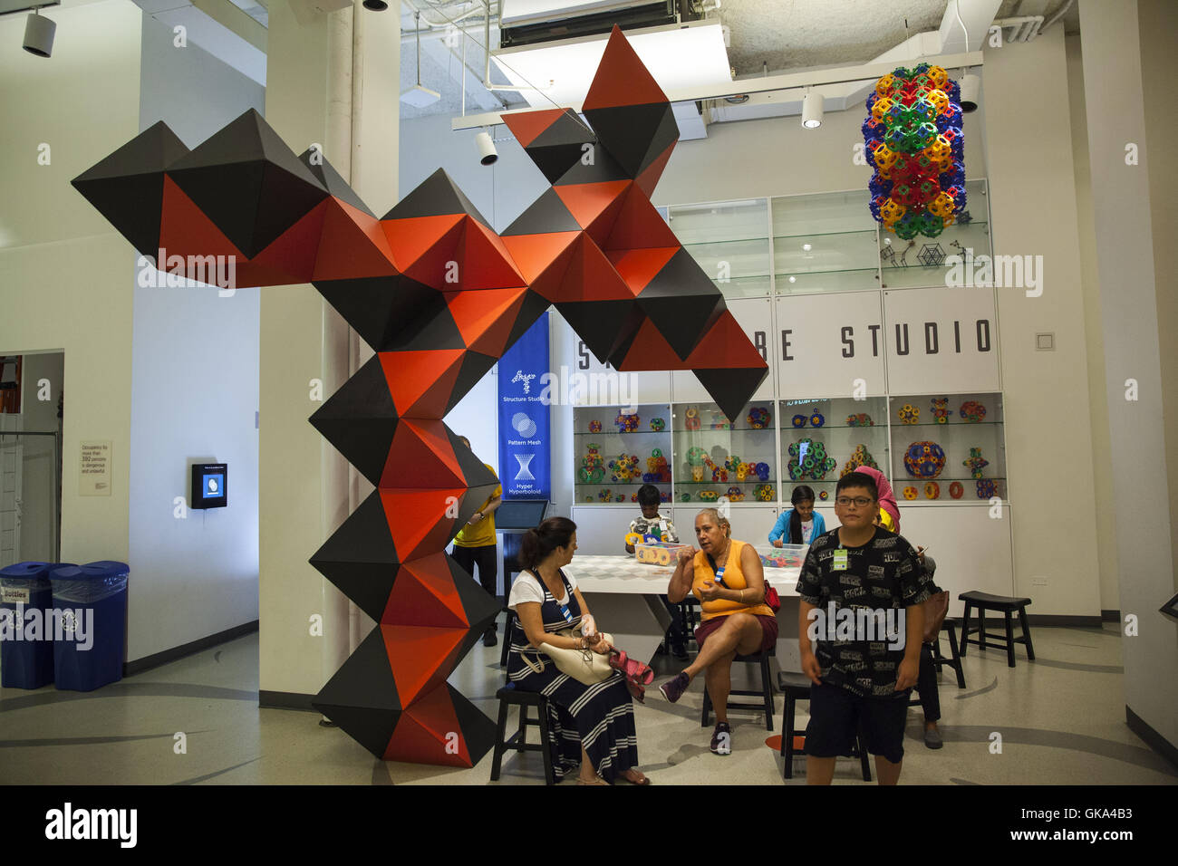 Children and adults explore mathematically based exhibits at the International Museum of Mathematics in New York City. Stock Photo