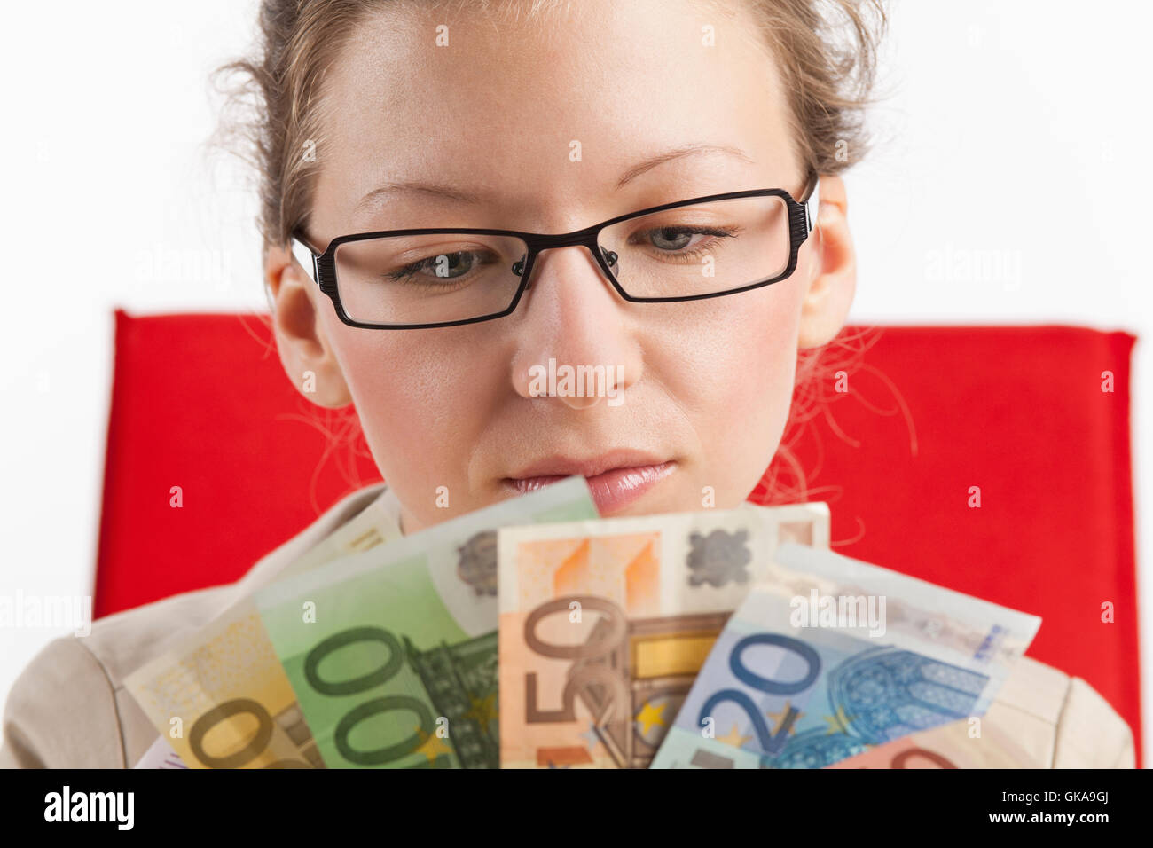 young woman looks at subjects from banknotes Stock Photo