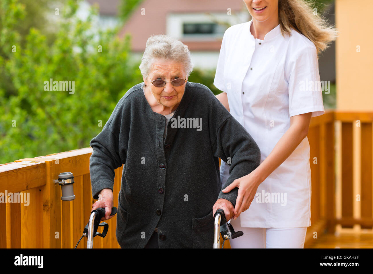 age and nursing - nurse and a senior citizen with walker young nurse and fem Stock Photo