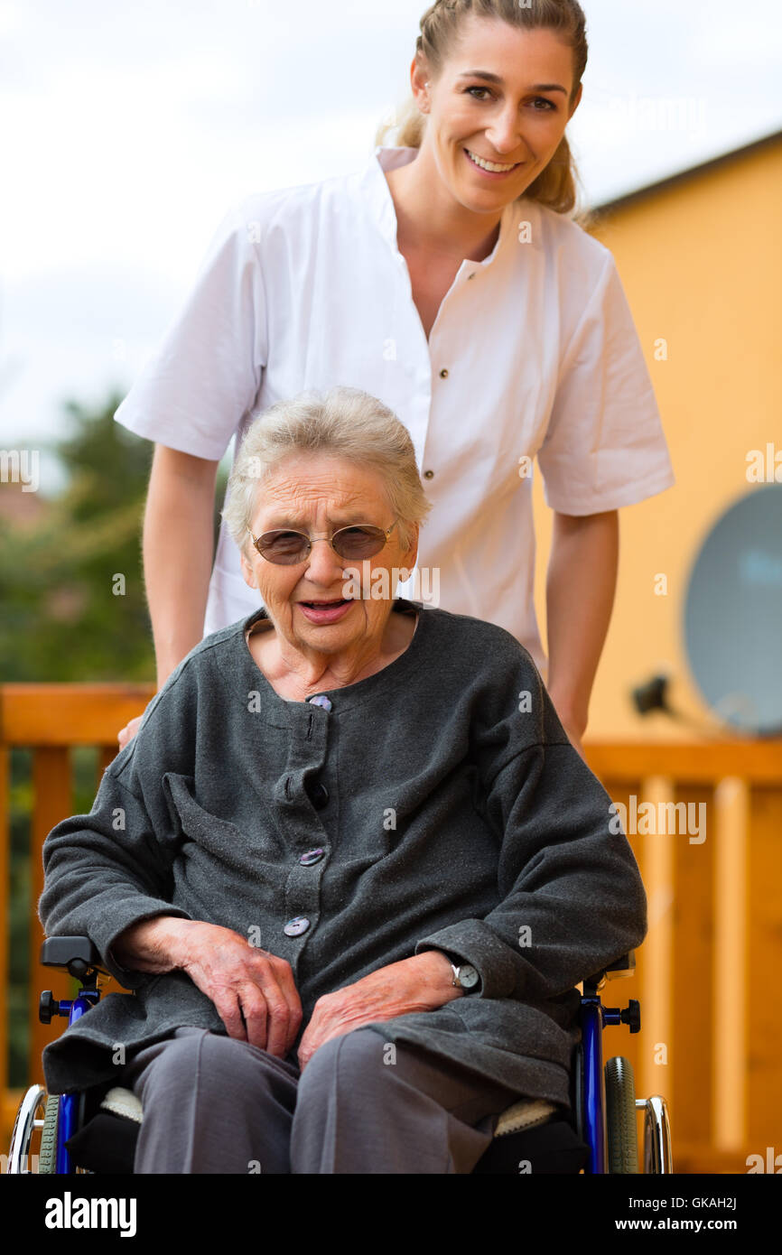 age and care - nurse and a senior citizen with walker Stock Photo