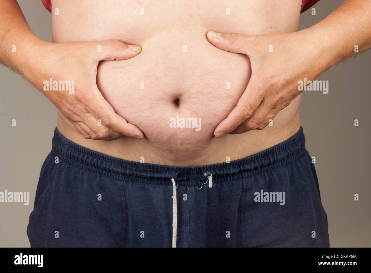 Treatment of obesity. Fat man with syringe making insulin injection to