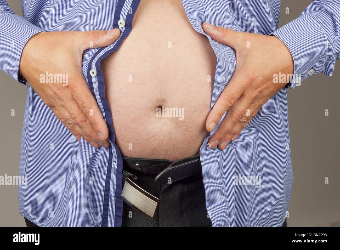 Treatment of obesity. Fat man with syringe making insulin injection to