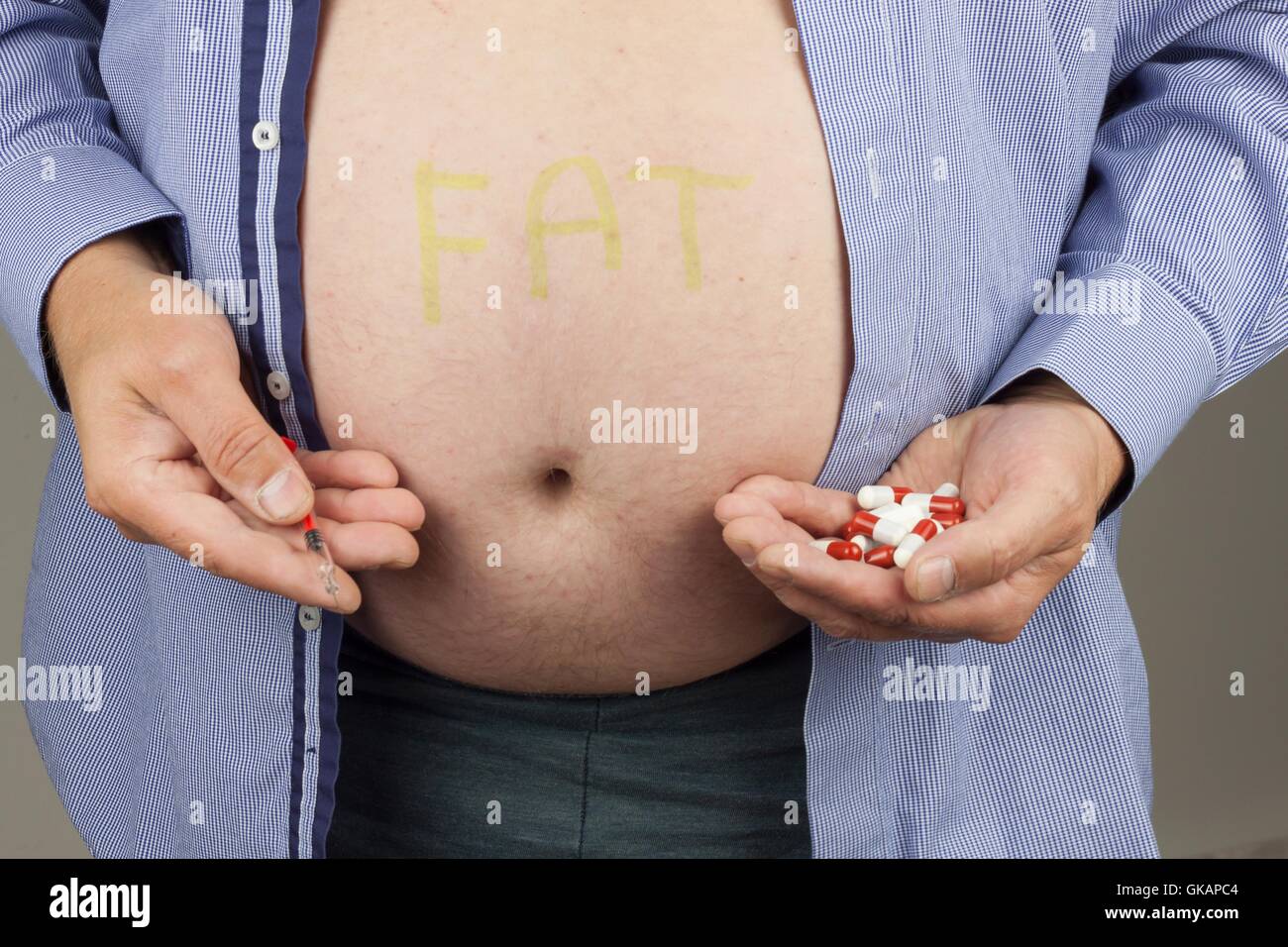 Treatment of obesity. Fat man with syringe making insulin injection to