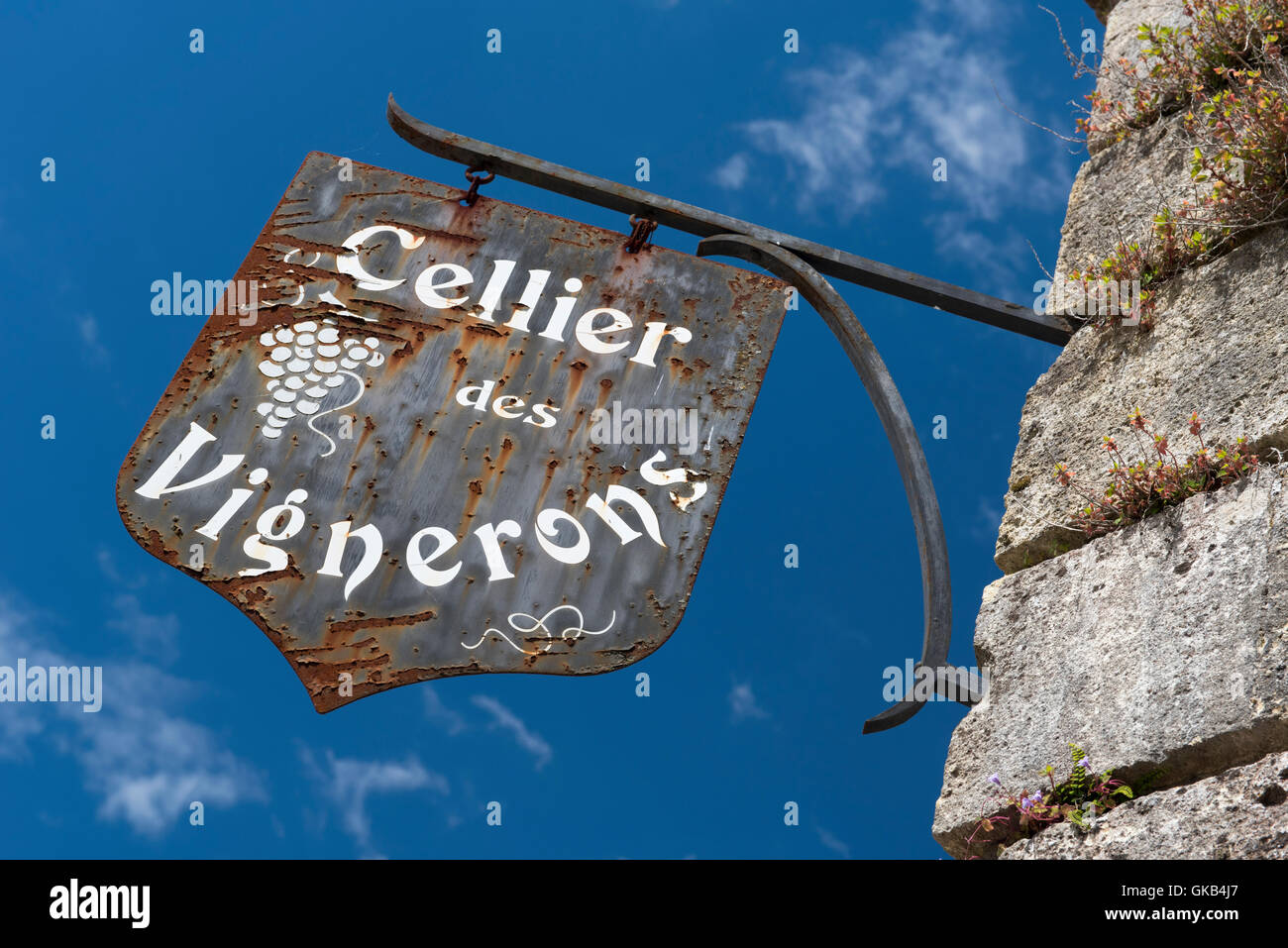 Old rusty metal  Cellier des Vignerons  ( cellar winemakers ) sign against a blue sky. Stock Photo