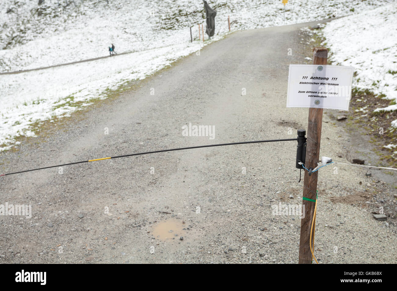 Sign with CAUTION, electric fence on a mountain path Stock Photo