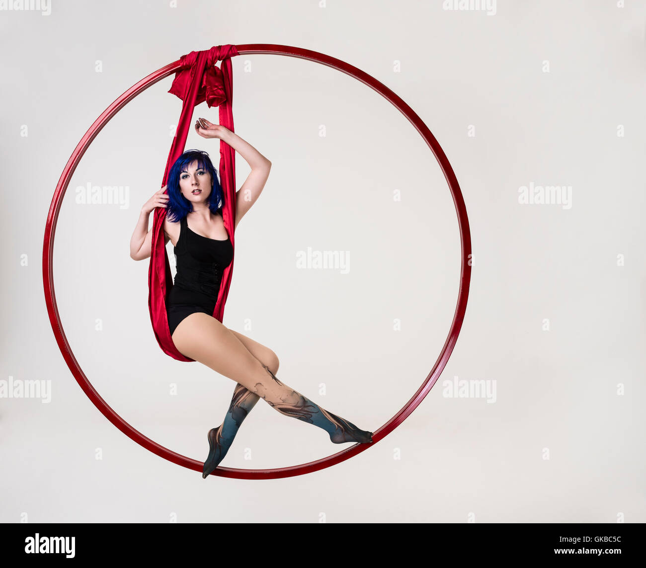 Young woman in hanging in a floating red ring, Virginia Beach, VA Stock Photo