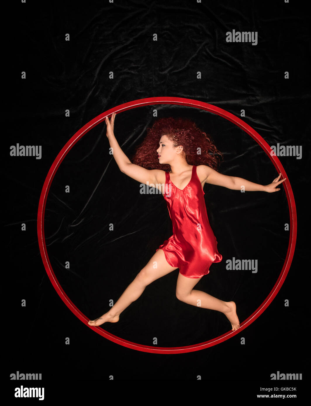 Young redhead woman in a red dress in a red ring Stock Photo
