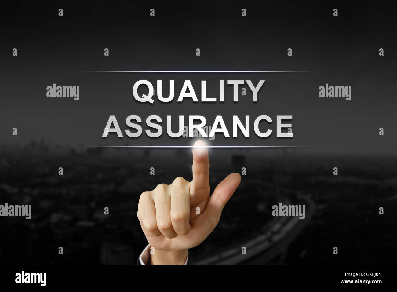 business hand clicking quality assurance button on black blurred background Stock Photo