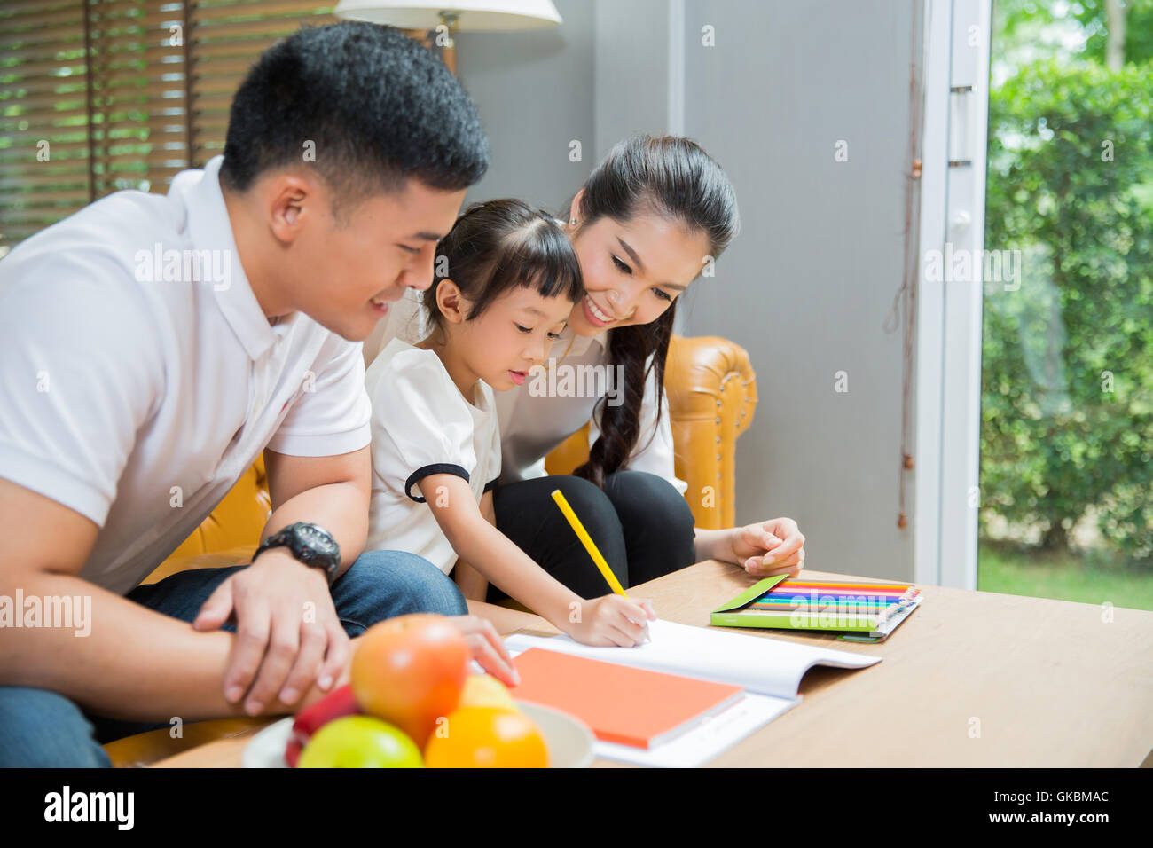 Father and mother Teaching children to do their homework at home Stock ...