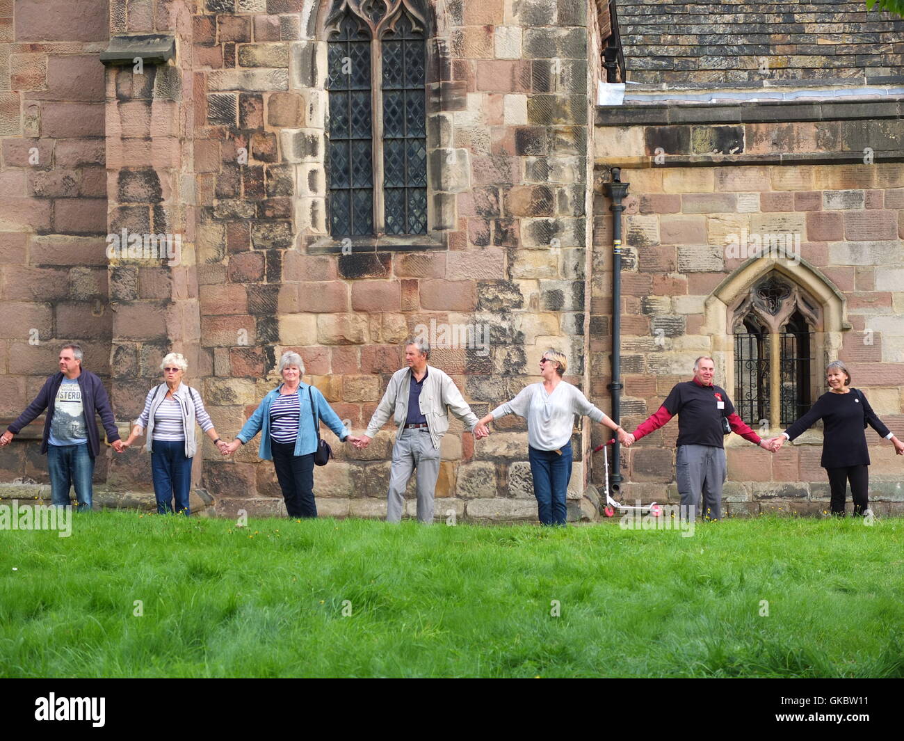 Clypping (or 'Clipping') the Church at Wirksworth, Derbyshire - townsfolk link arms and 'embrace' the church. Stock Photo