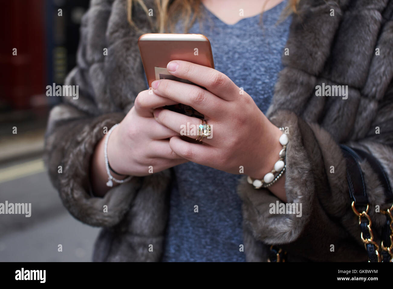 Mid section detail of woman using a smartphone in the street Stock Photo