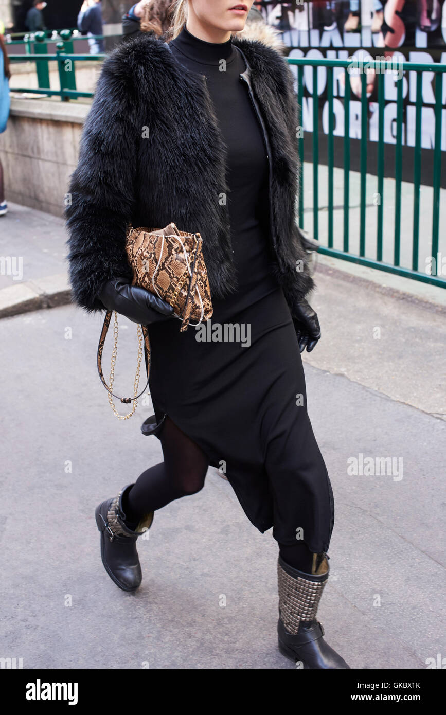 Woman with fur jacket and snakeskin bag walking in street Stock Photo