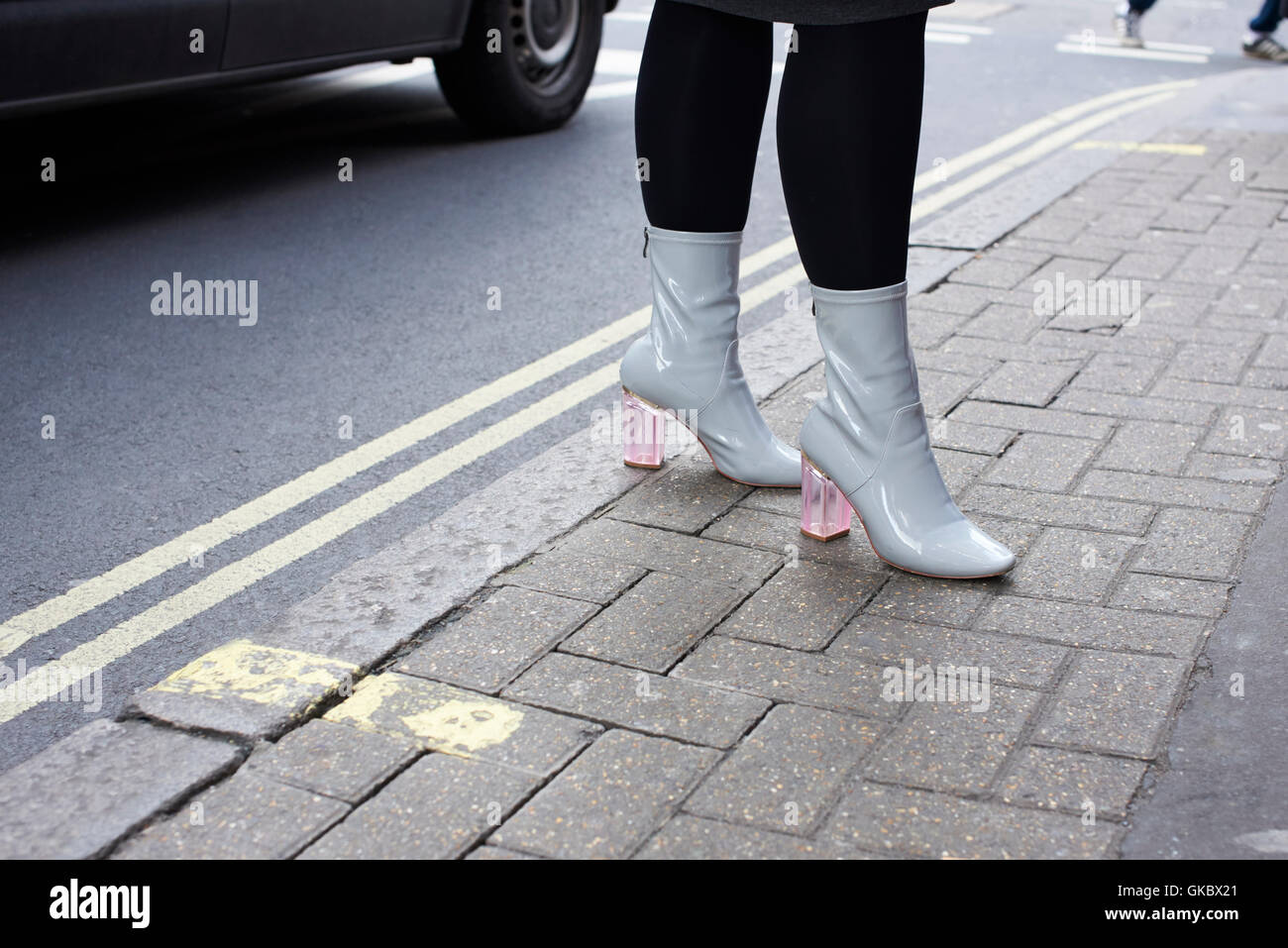 Close up of woman’s pale grey patent boots with pink heels Stock Photo