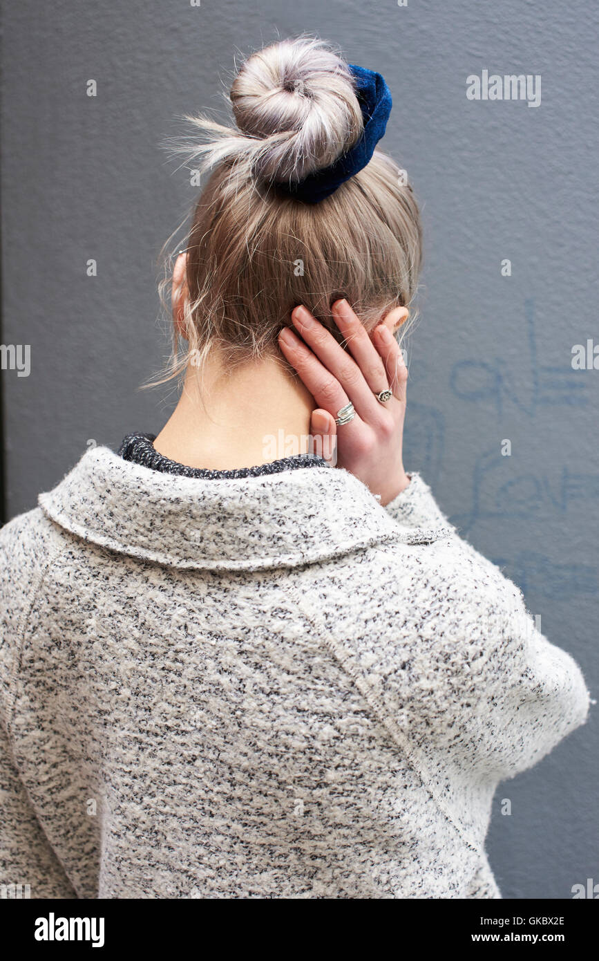 Back view of a woman with hair done up in a bun, vertical Stock Photo