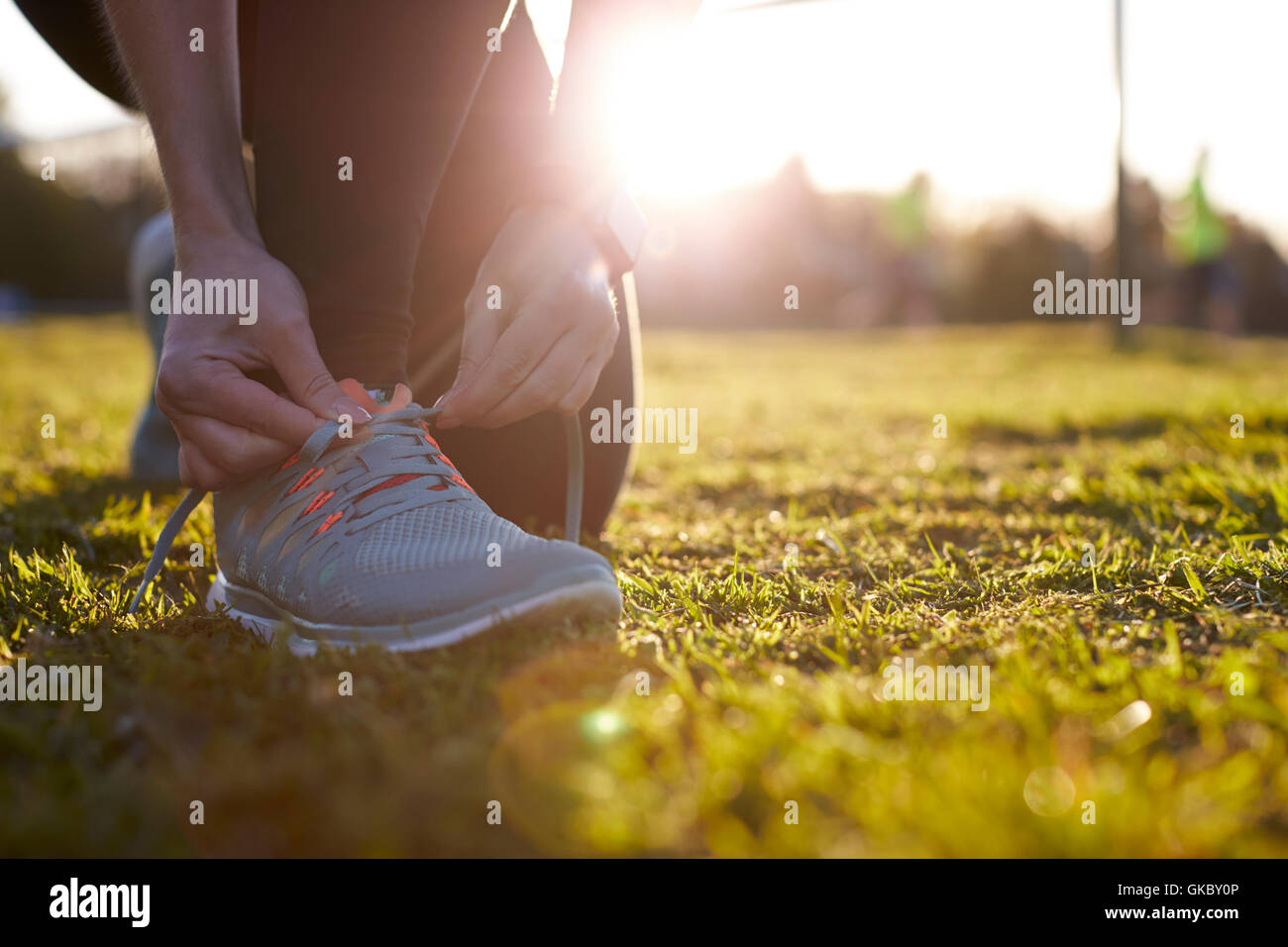 Close Up Of Woman Lacing Trainers Before Outdoor Exercise Stock Photo