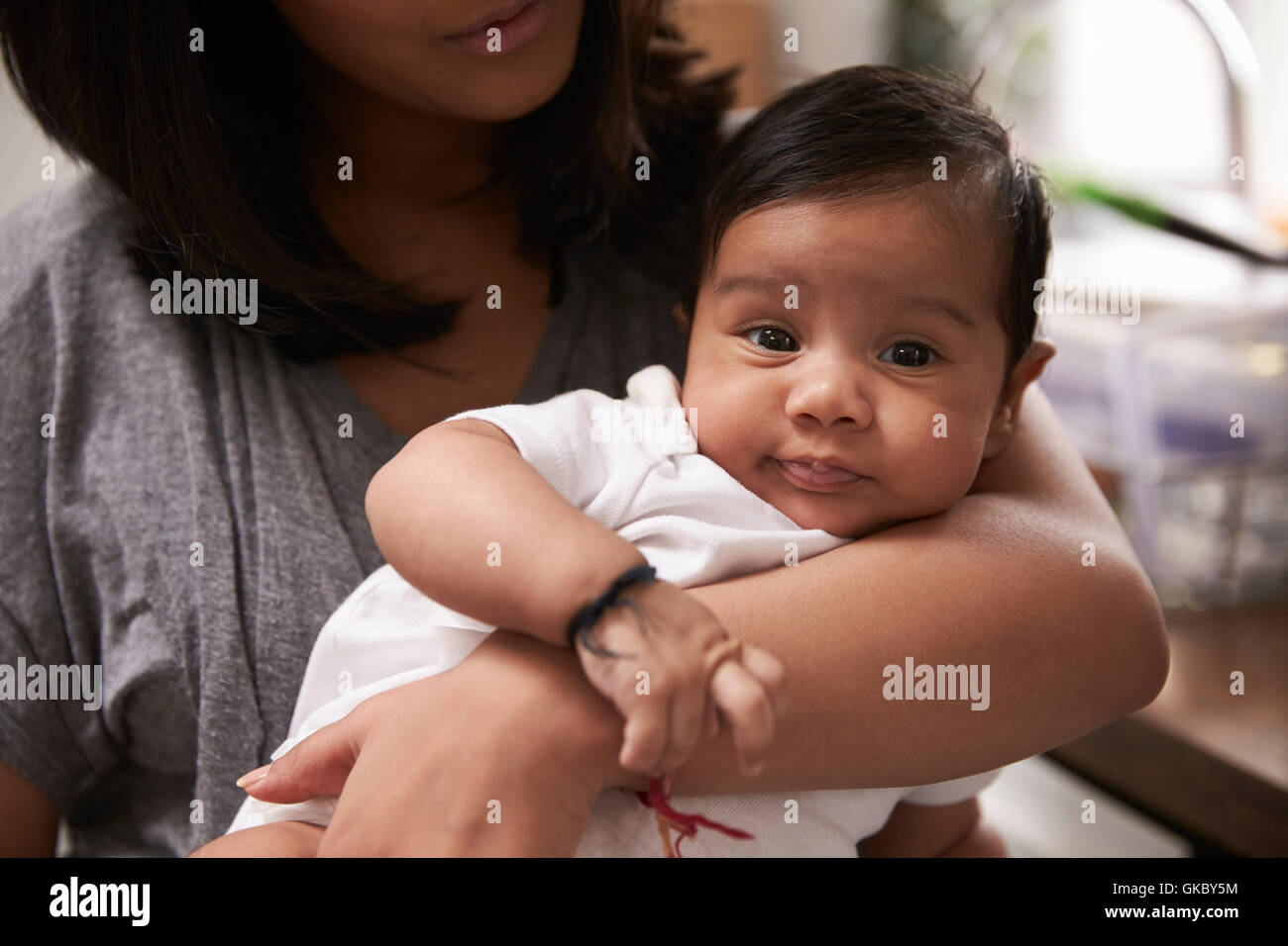 Close Up Of Baby Boy Being Held By Mother Stock Photo