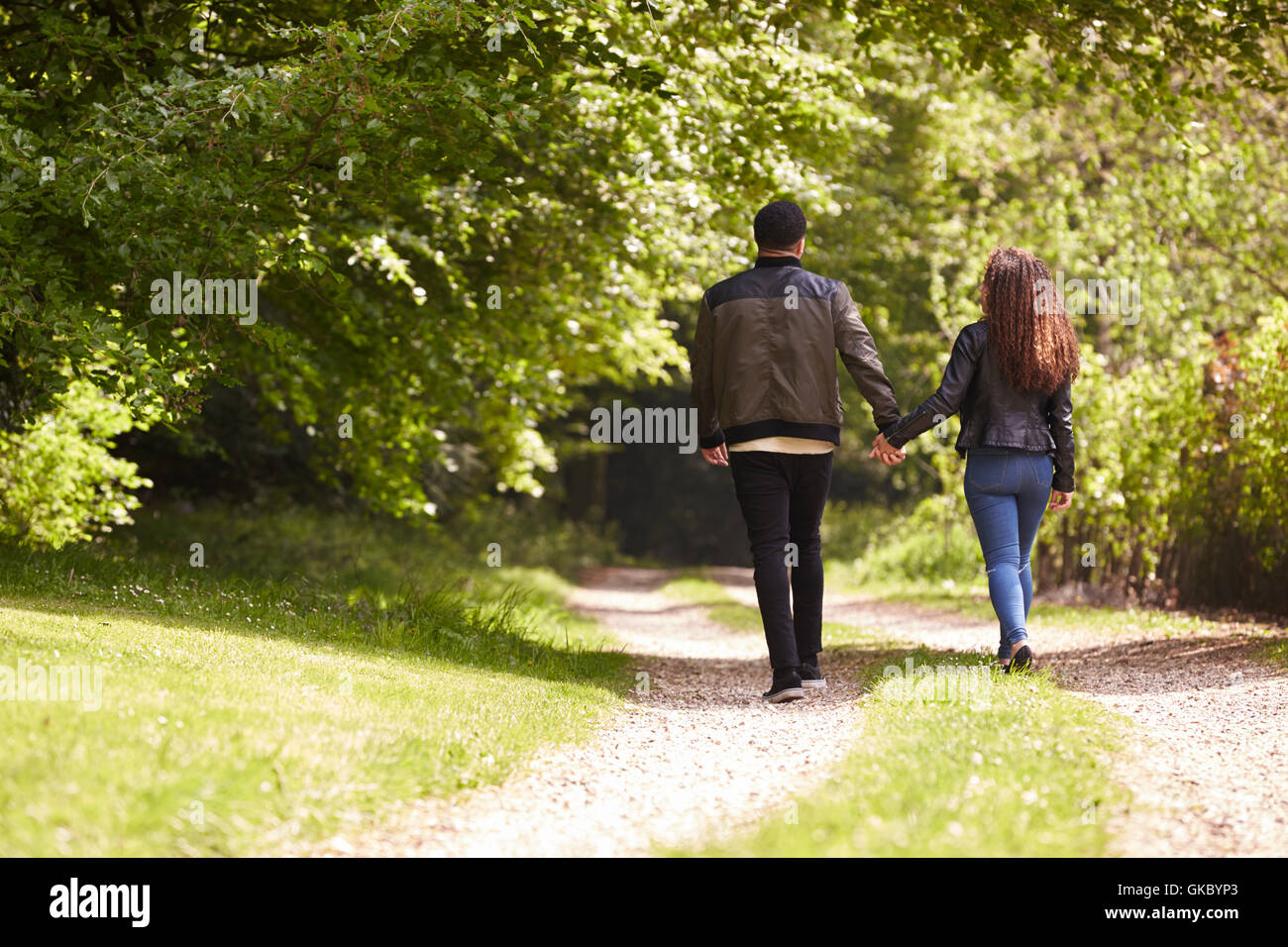Couple holding hands and walking in rural setting, back view Stock ...