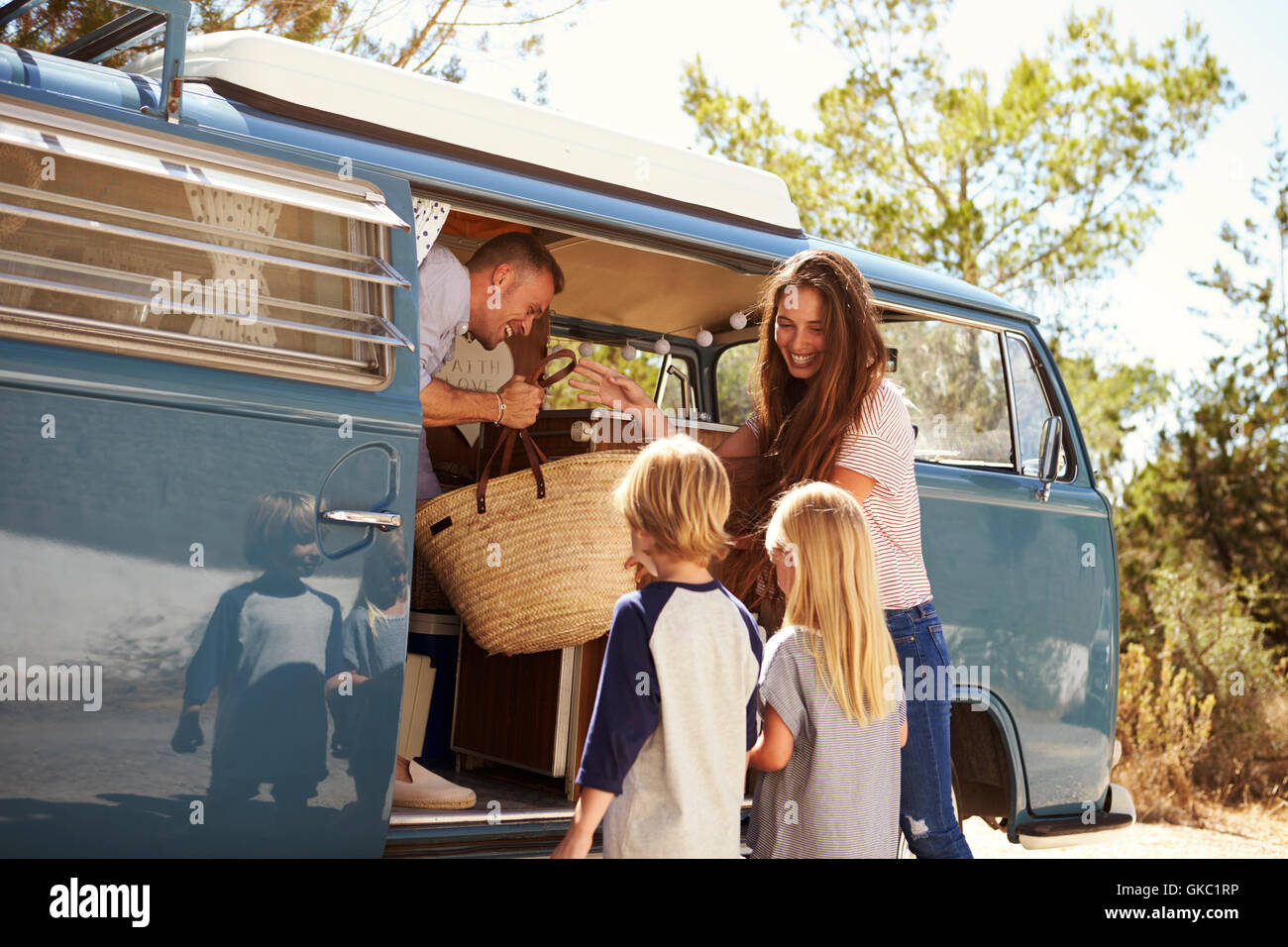 Family packing up their camper van for a road trip vacation Stock Photo