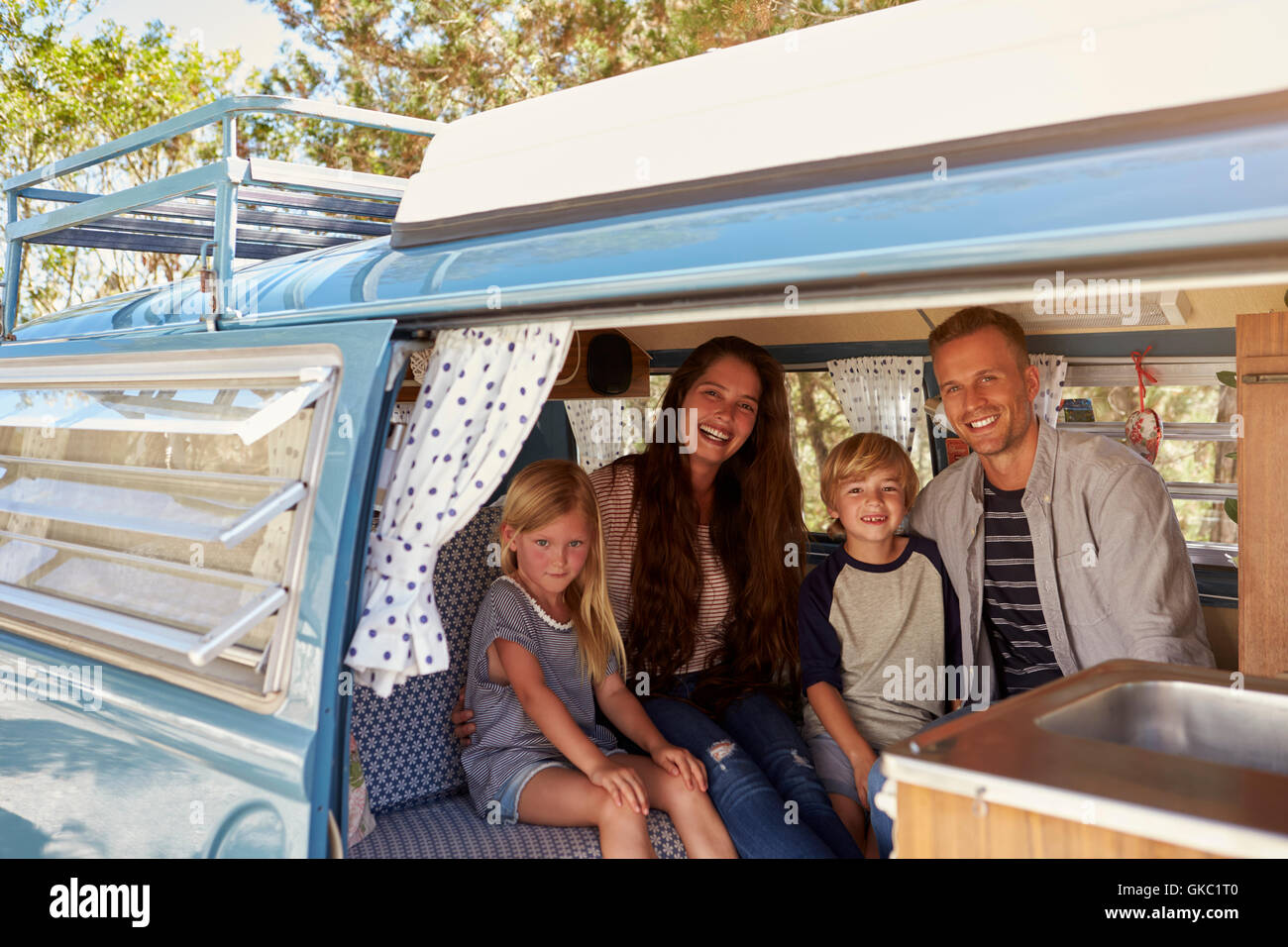 Family inside vintage camper van, seen through open door Stock Photo