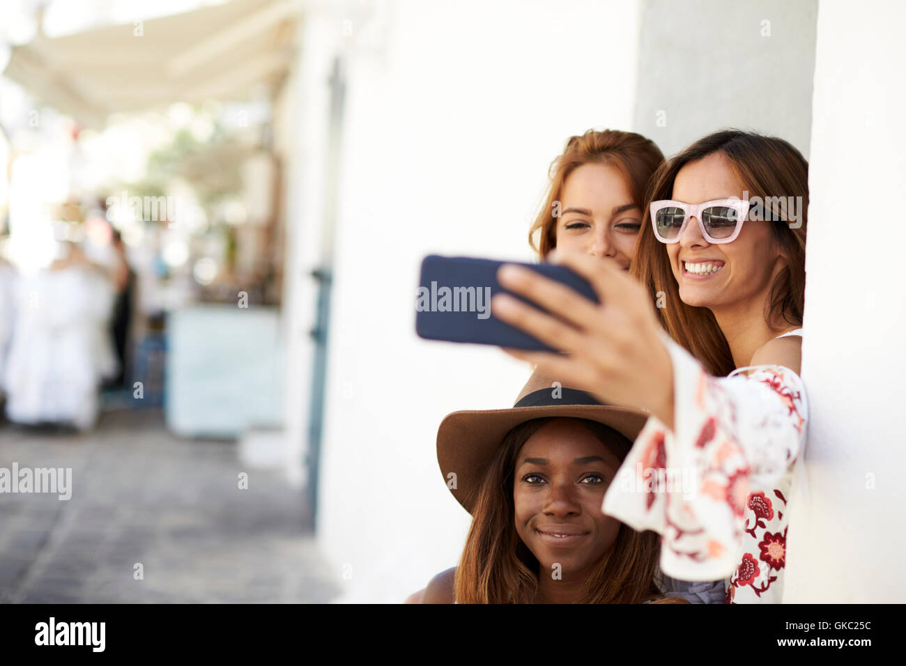 Three female friends taking a selfie in the street, Ibiza Stock Photo