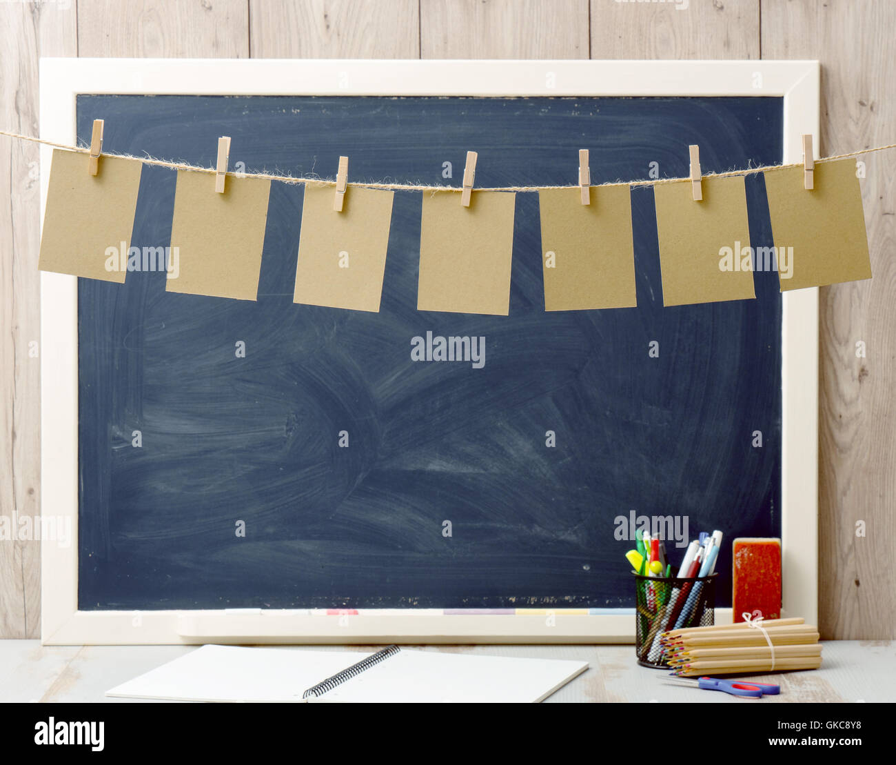 seven sheets of paper hanging and blackboard in background Stock Photo