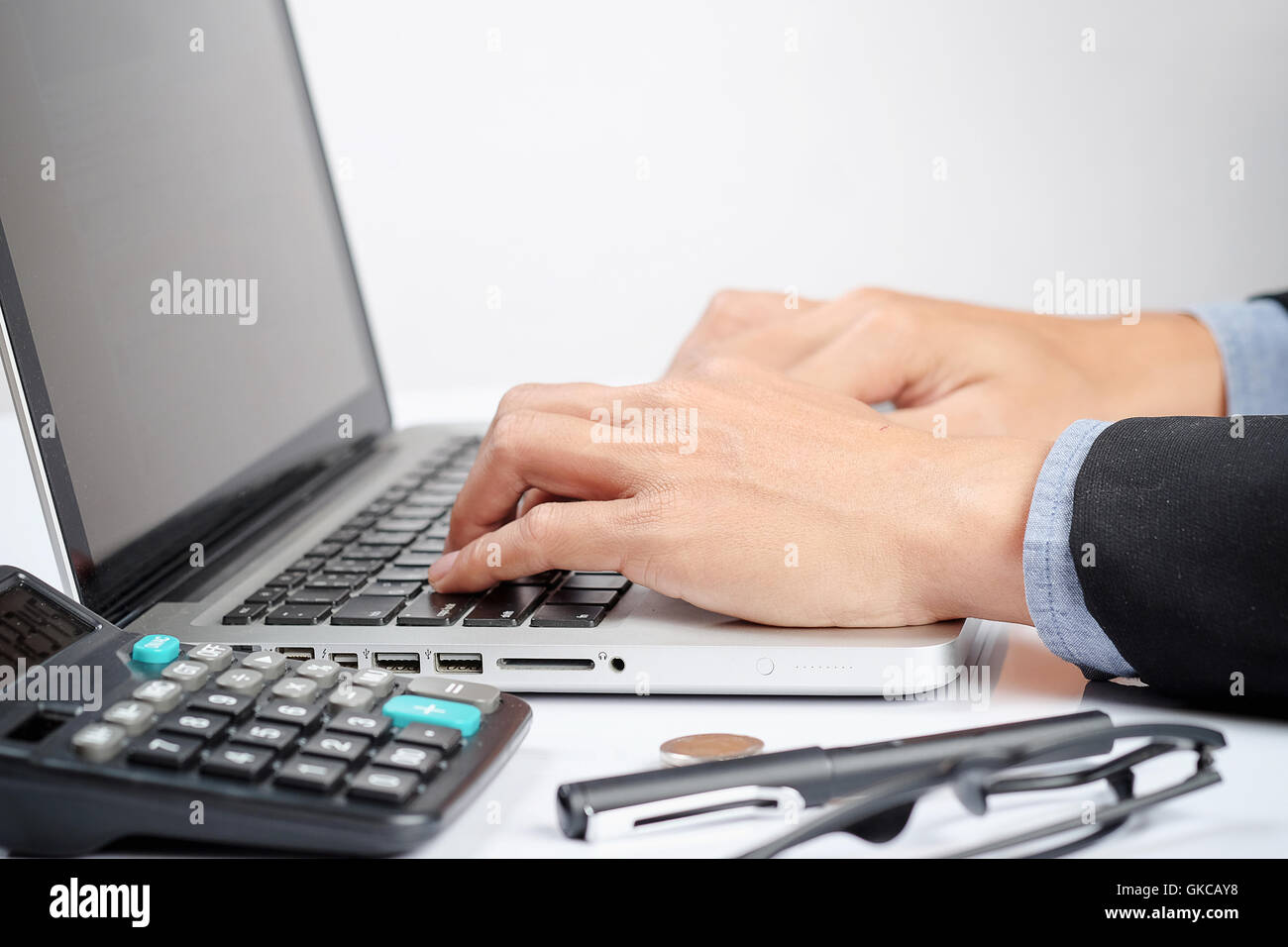 Close up business man typing on a modern laptop in an office Stock Photo