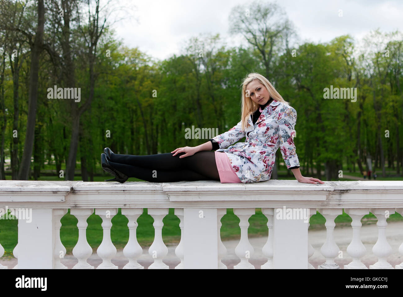 Blond Railing blonde girl sitting on the railing Stock Photo - Alamy