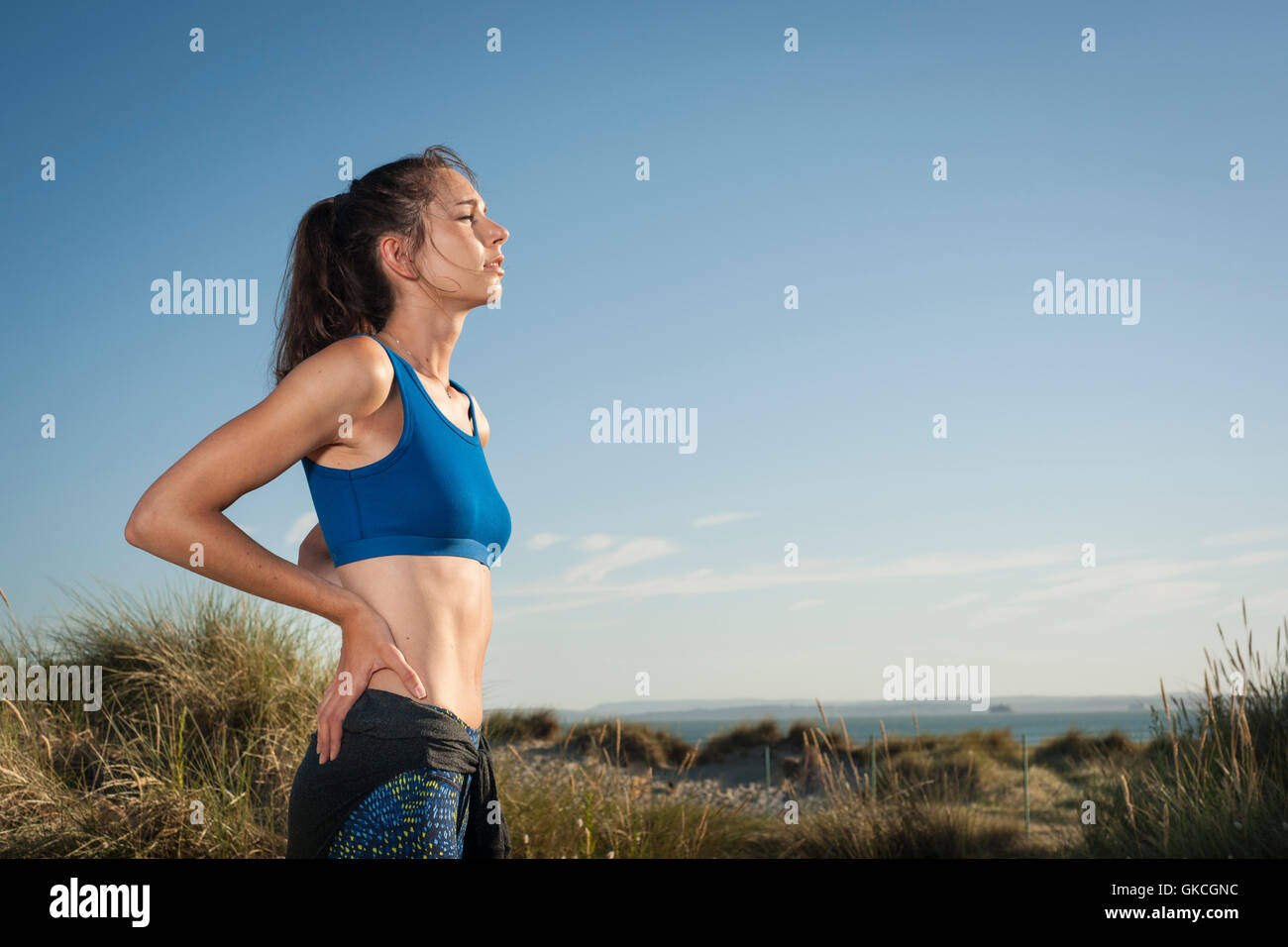 woman resting after running and exercise in sand dunes Stock Photo