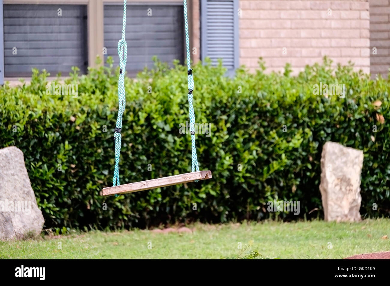 A child's rope swing hanging from a tree in a front yard of a home in Oklahoma, USA. Stock Photo