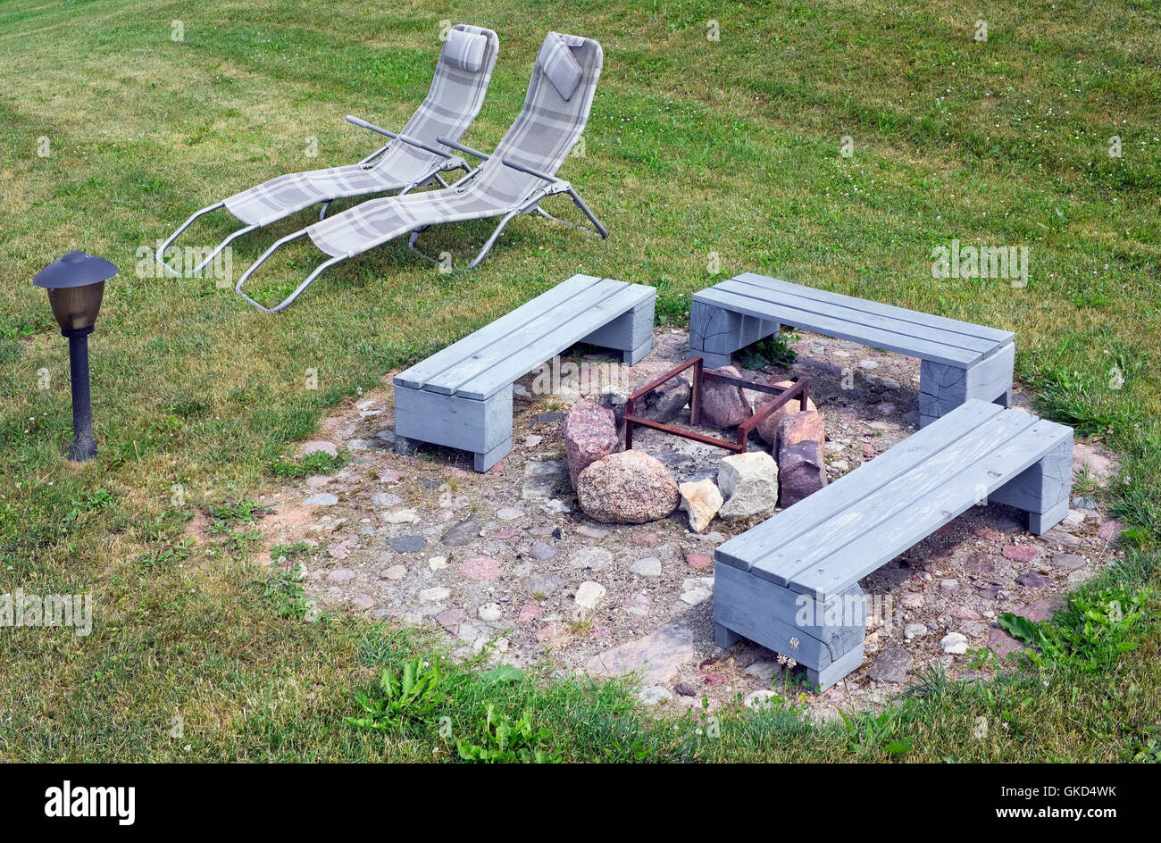 The area for a barbecue on a green grass of a garden meadow. Wooden