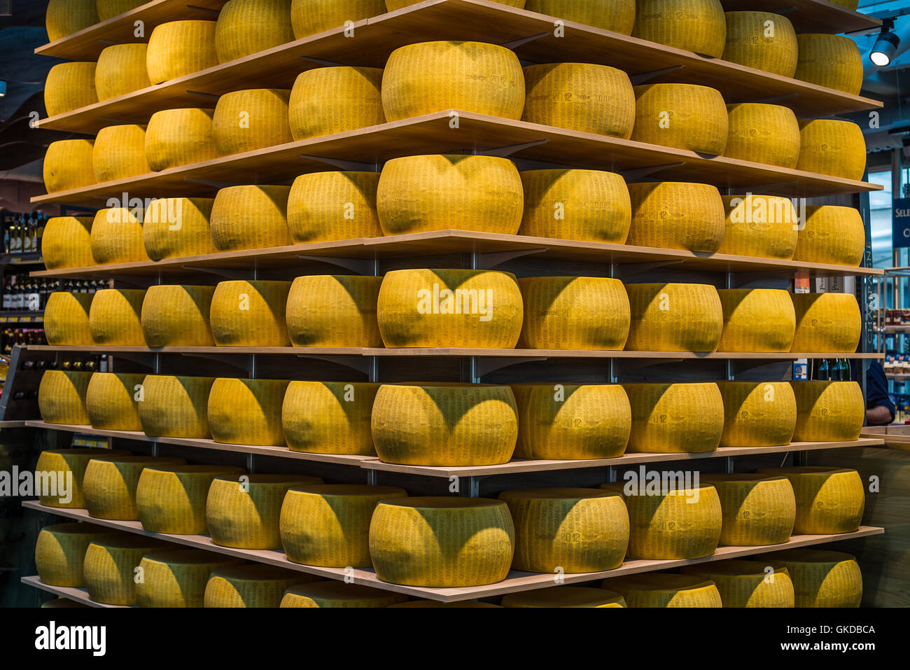 Wheels of Parmigiano-Reggiano or Parmesan cheese on the shelves of Ghiaia market in Parma. Emilia- Stock Photo