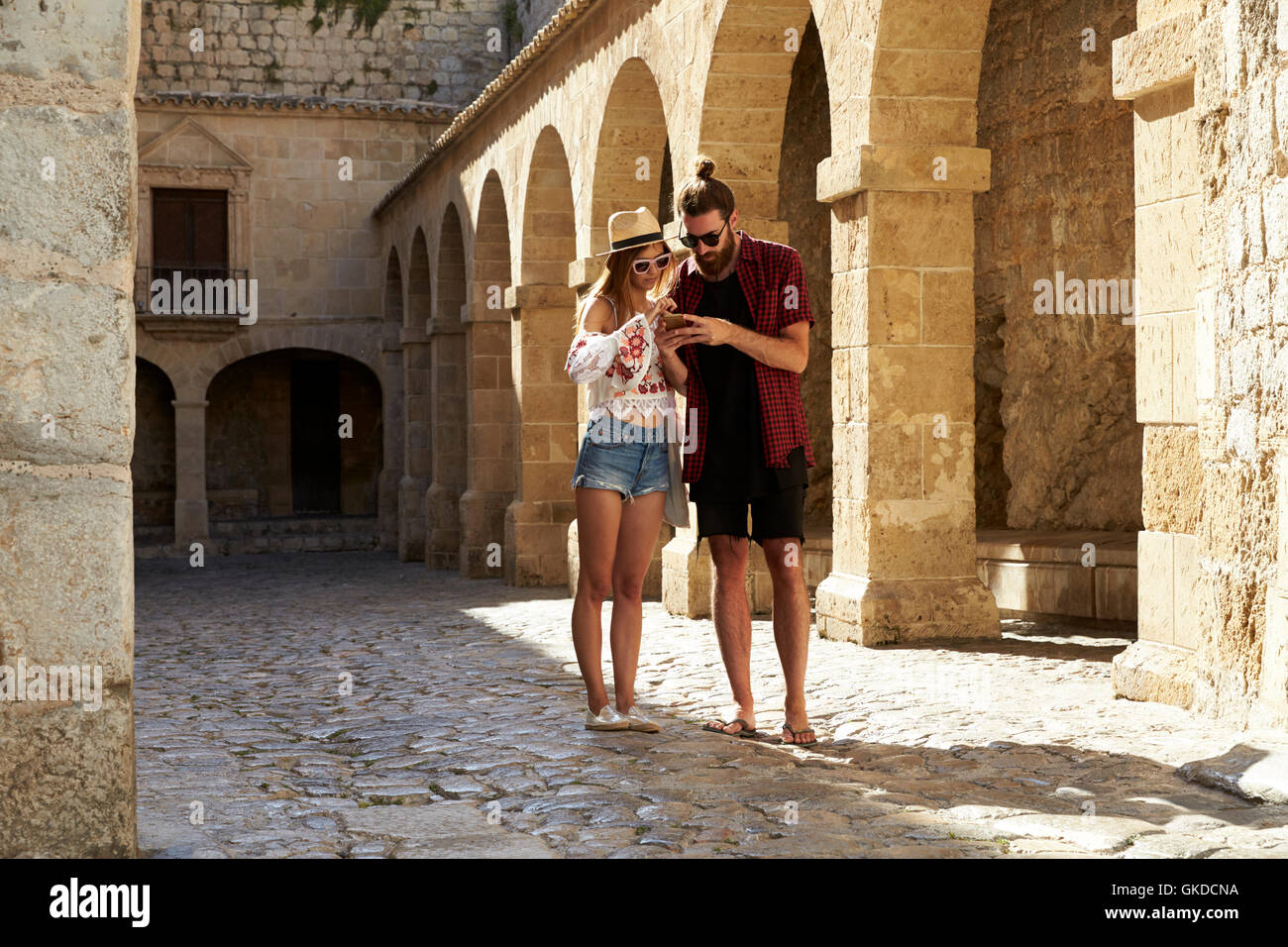 A couple sightseeing in Ibiza using a phone for guidance Stock Photo