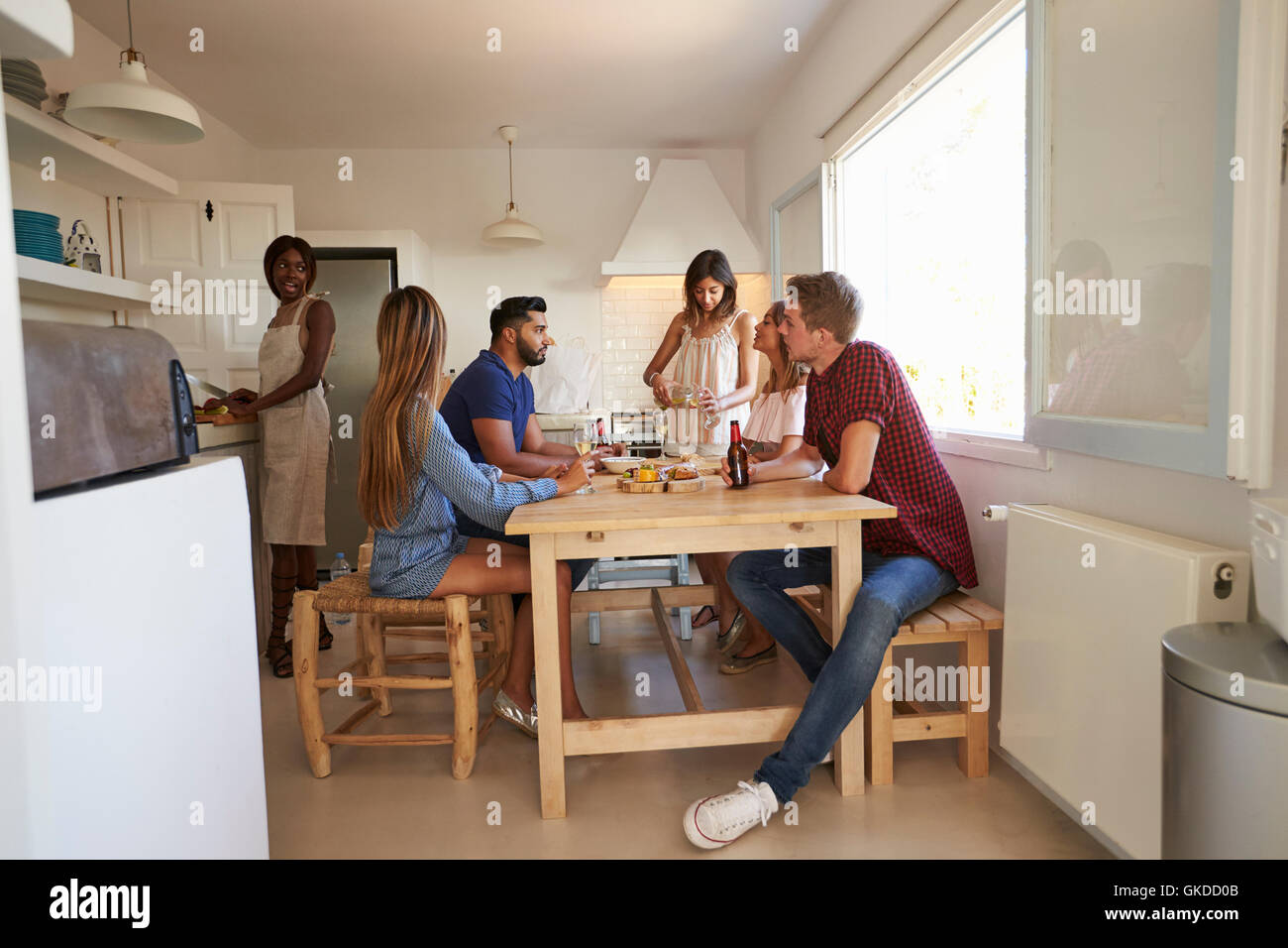 Group of friends at dinner party, one of them preparing food Stock Photo