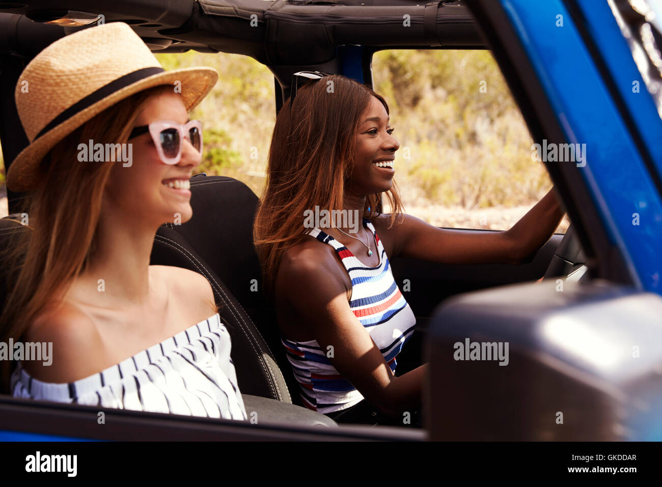 Two Female Friends Driving Open Top Car On Country Road Stock Photo - Alamy