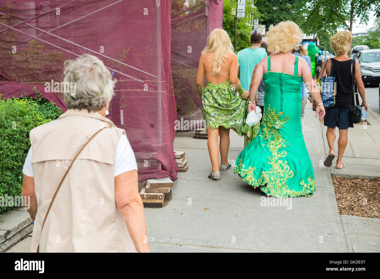 Montreal, CA - 14 August 2016: Drag-queens walking on the street in front of an old lady after Pride Parade. Stock Photo