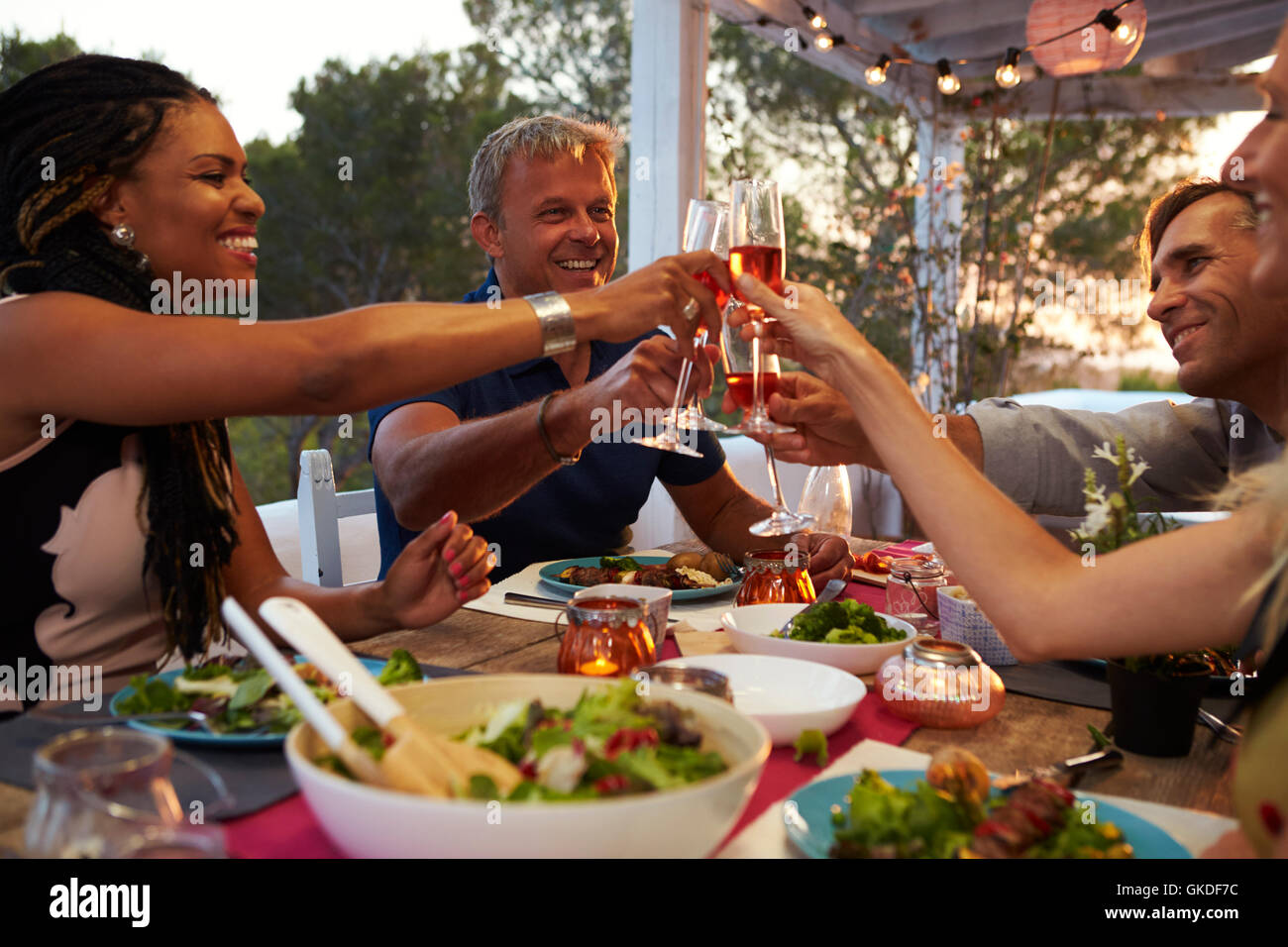 Couples make a toast at dinner on a roof terrace, close up Stock Photo