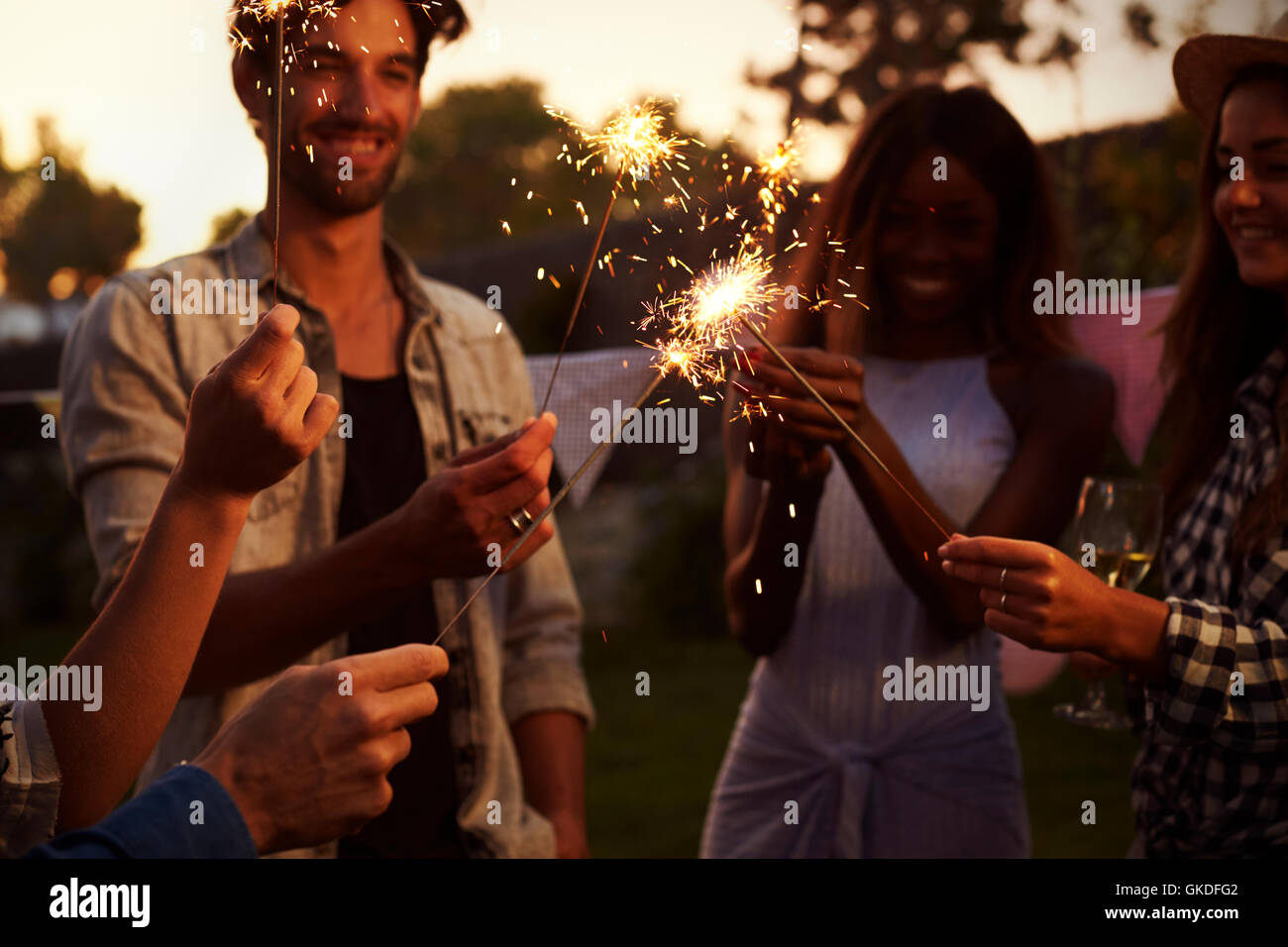 Group Of Friends With Sparklers Enjoying Outdoor Party Stock Photo