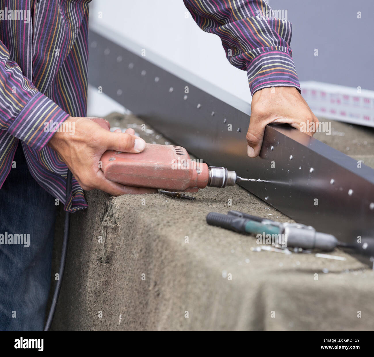 Close up of worker drilling holes in aluminium construction frame with