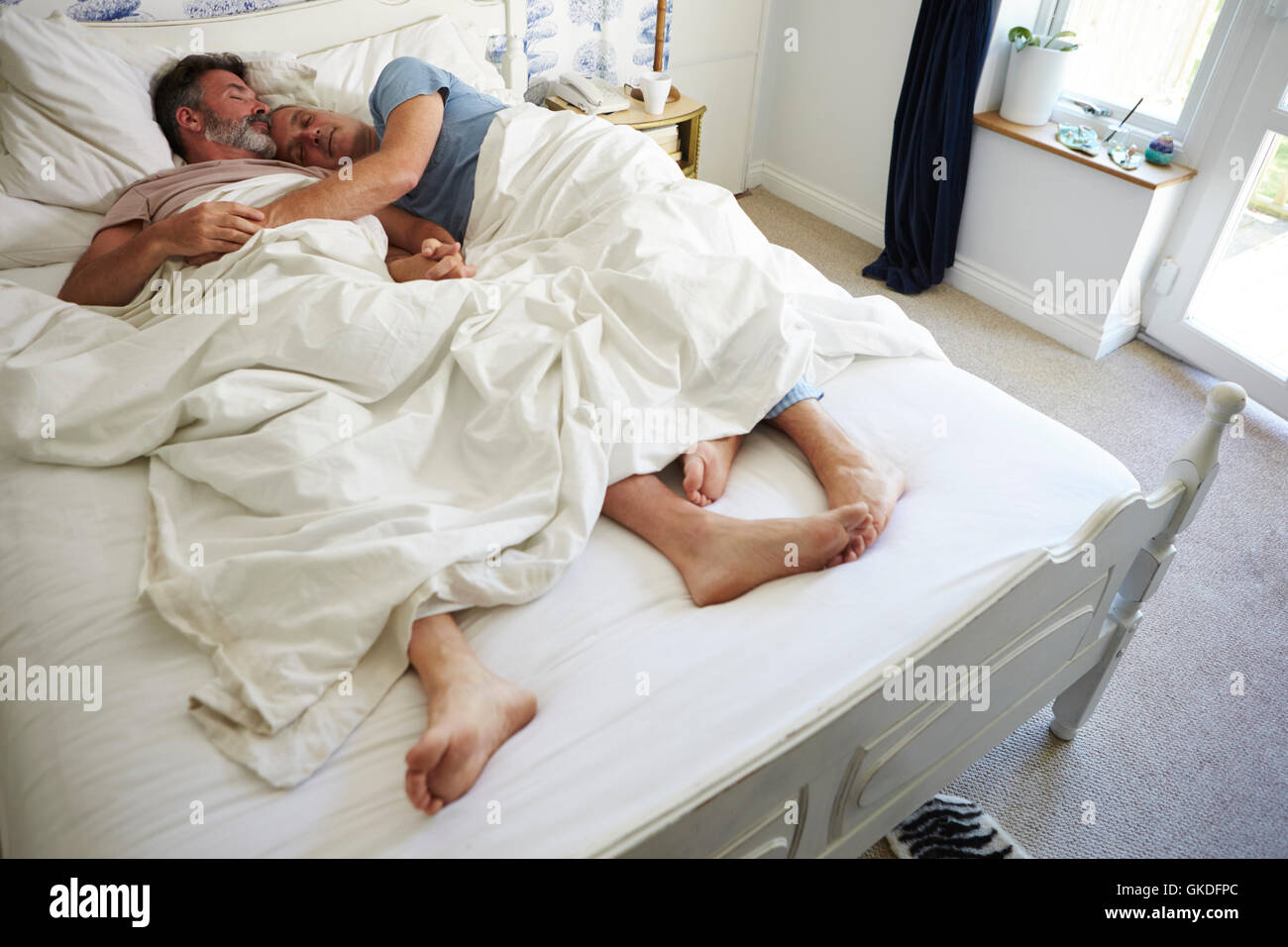 Gay male couple getting ready for work in their bedroom Stock Photo