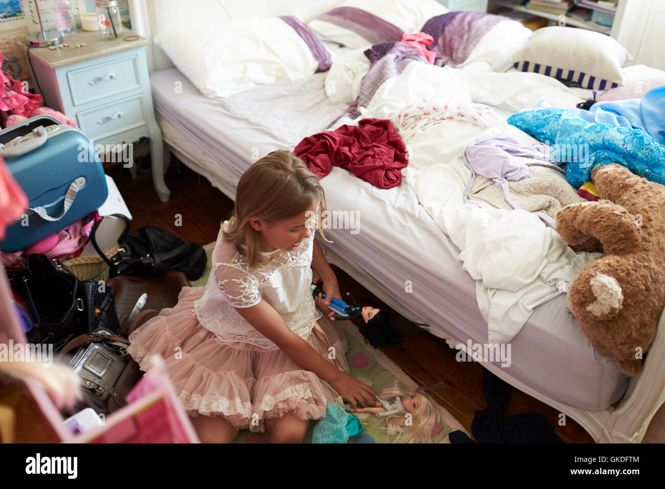 Young Girl Playing In Untidy Bedroom Stock Photo