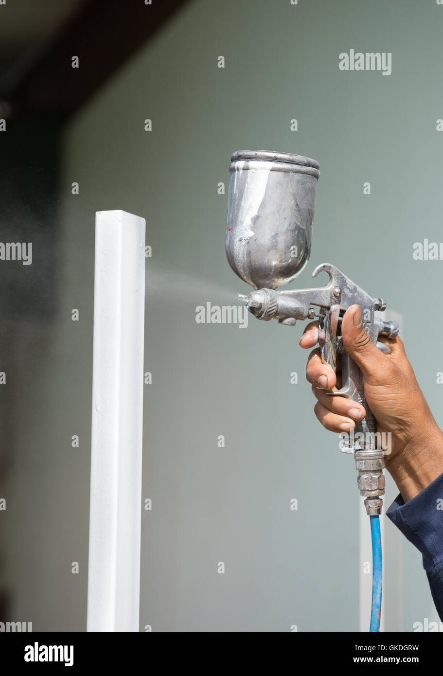 Metal spray gun for painting in a paint shop. Accessories for painting  works and protective clothing. Dark background Stock Photo - Alamy
