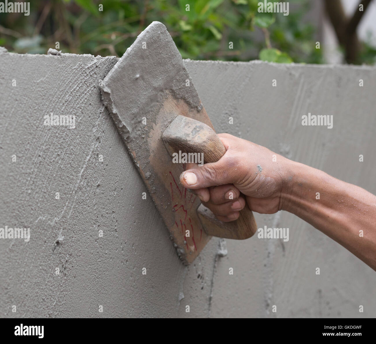 hand of builder worker use trowel plastering concrete at wall Stock Photo