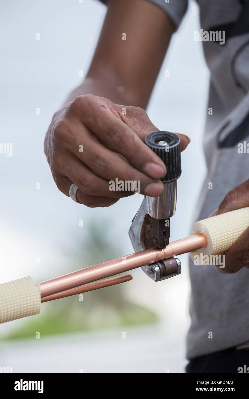 worker cutting the copper pipe of air conditioner Stock Photo