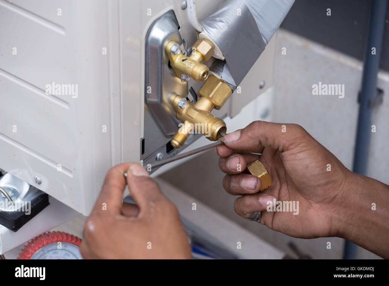 installation of the air conditioner, worker open drip valve Stock Photo