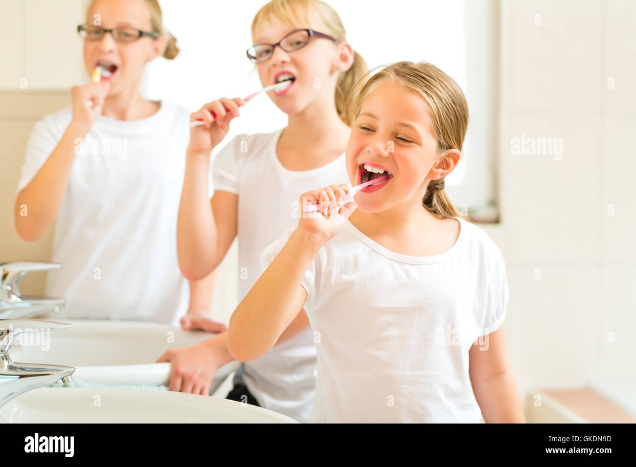 girl brushing teeth in the bathroom Stock Photo