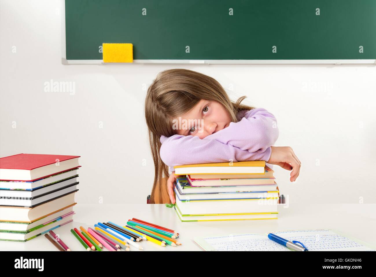 schoolgirl leaning on a pile of books Stock Photo - Alamy